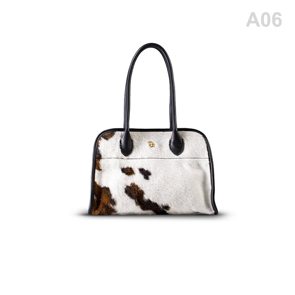 woody Frida Damen-Handtasche aus Natur-Fell in Schwarz, getragen am Arm