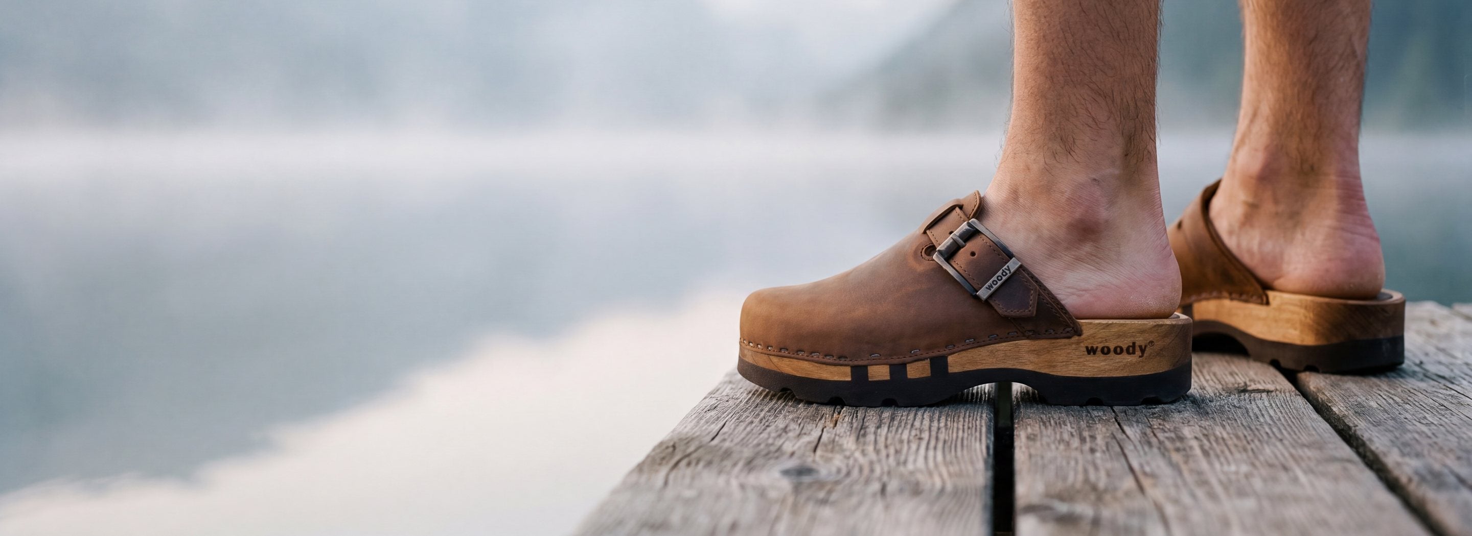 woody Lukas Herren Clog, getragen auf einem Holzsteg am Bergsee